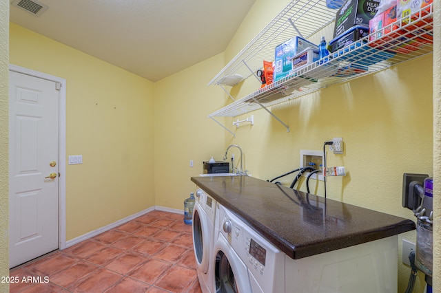 laundry area with sink, tile patterned floors, and washer and dryer