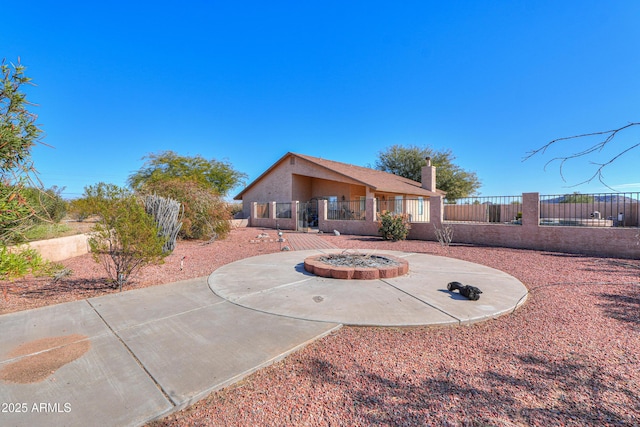 back of property with an outdoor fire pit