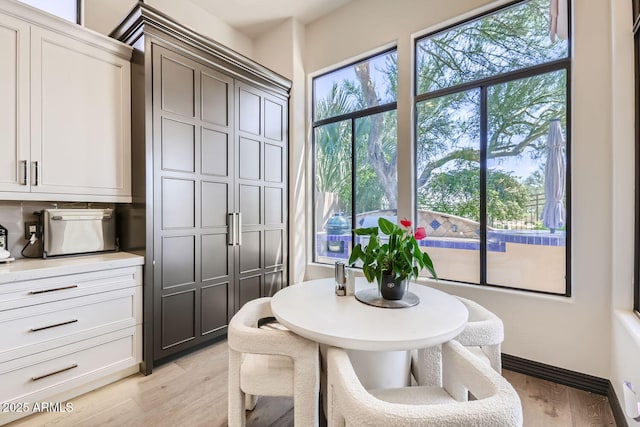 dining area with light wood-style flooring and baseboards