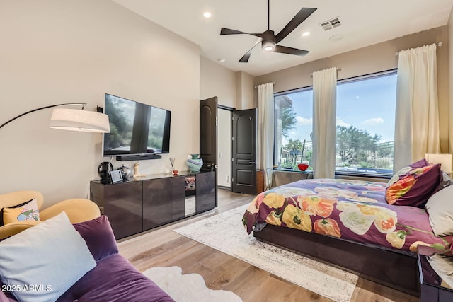 bedroom with visible vents, lofted ceiling, light wood-style flooring, and recessed lighting