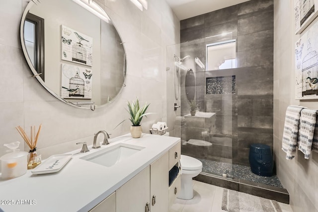 full bath featuring toilet, tile patterned flooring, vanity, a walk in shower, and tile walls