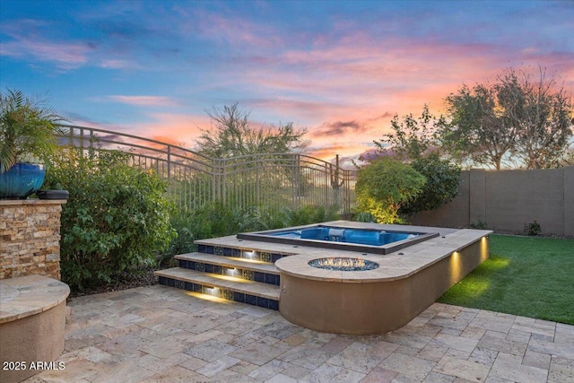 pool at dusk featuring fence private yard, a patio area, and a fire pit