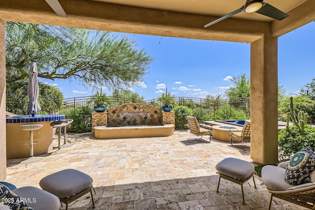 view of patio featuring a fire pit, ceiling fan, and fence