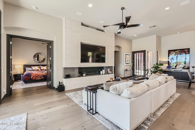 living room featuring light wood finished floors, ceiling fan, visible vents, and recessed lighting