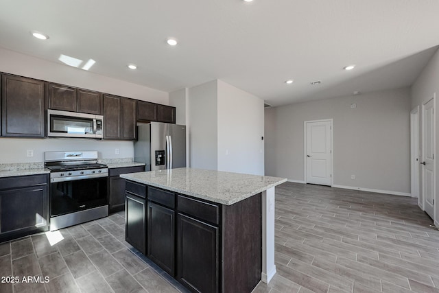 kitchen with stainless steel appliances, recessed lighting, a center island, and wood finish floors