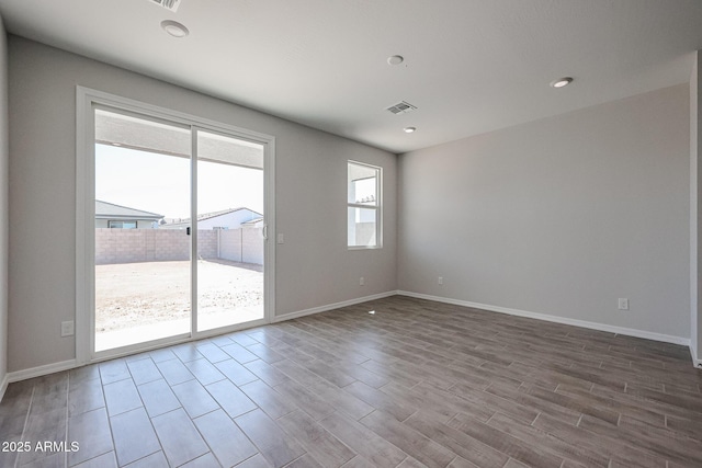 spare room with visible vents, baseboards, recessed lighting, and wood finished floors