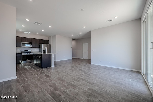 kitchen with visible vents, recessed lighting, stainless steel appliances, open floor plan, and baseboards