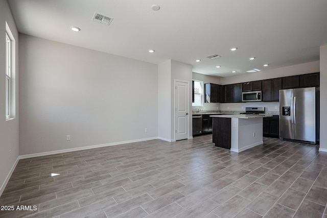 kitchen featuring open floor plan, appliances with stainless steel finishes, visible vents, and a kitchen island