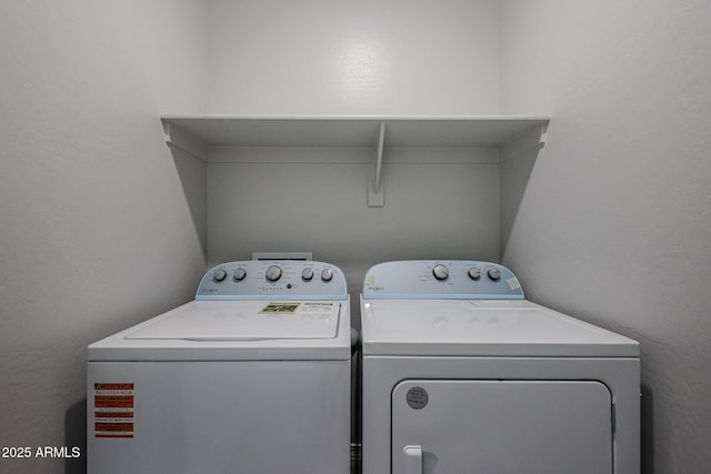 laundry room with a textured wall, independent washer and dryer, and laundry area