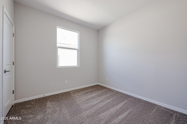 carpeted empty room featuring baseboards
