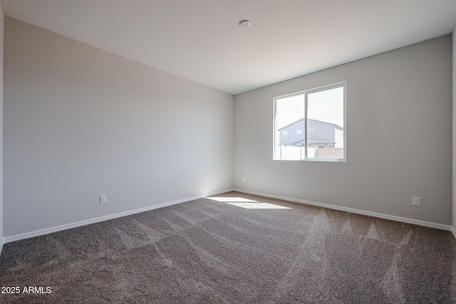 carpeted spare room featuring baseboards
