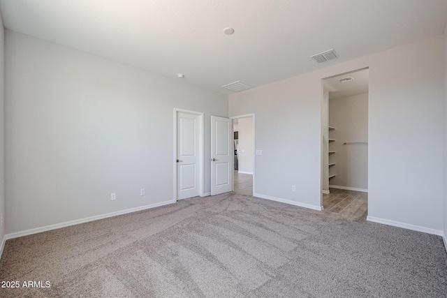 unfurnished bedroom featuring baseboards, visible vents, and carpet floors