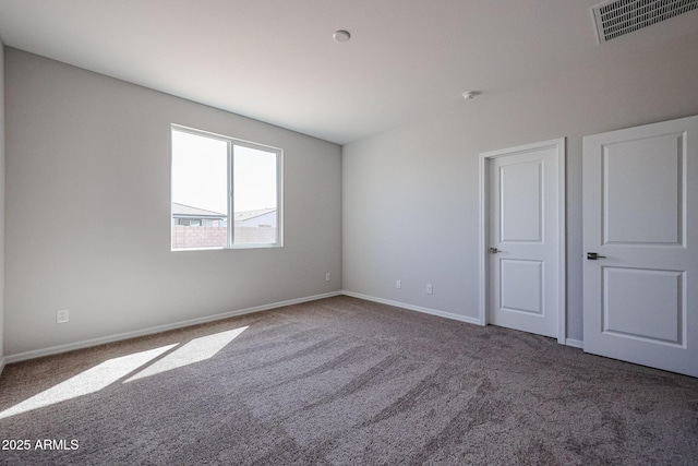unfurnished room with visible vents, baseboards, and carpet