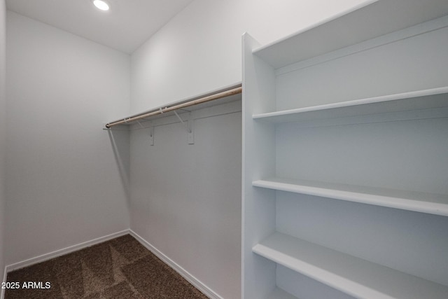 spacious closet featuring dark carpet