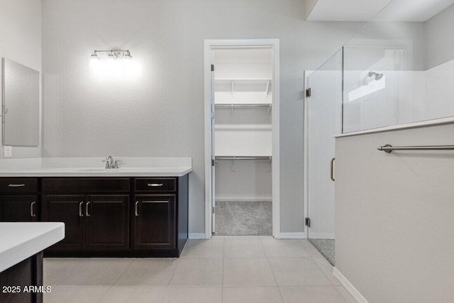 bathroom with vanity, a shower with shower door, and tile patterned floors