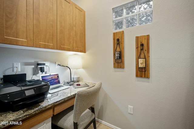 home office featuring baseboards and built in desk