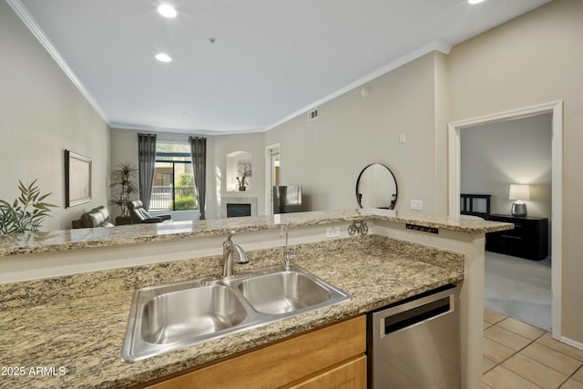 kitchen with dishwasher, ornamental molding, a fireplace, light tile patterned flooring, and a sink