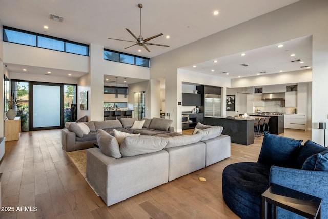 9148 N 66th Pl, Paradise Valley, AZ 85253 - living area with light wood-style flooring, a ceiling fan, a towering ceiling, and recessed lighting