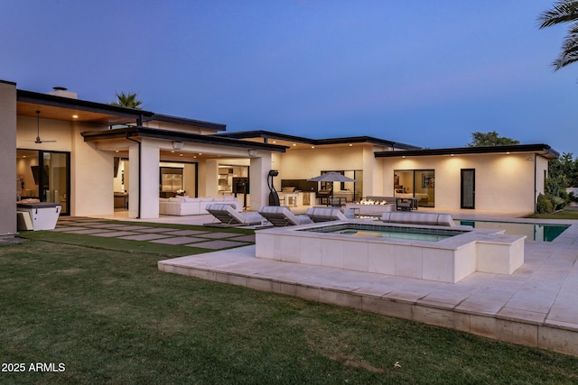 9148 N 66th Pl, Paradise Valley, AZ 85253 - back of house with outdoor lounge area, stucco siding, a patio, and an in-ground hot tub