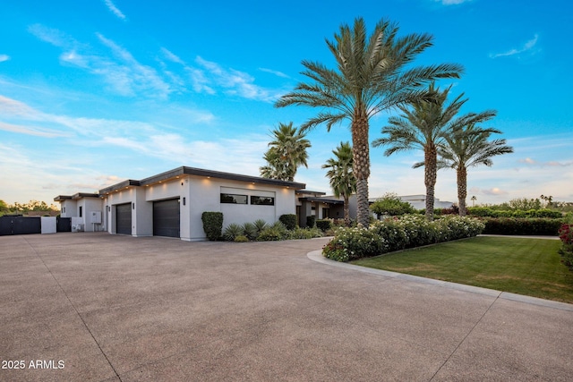 9148 N 66th Pl, Paradise Valley, AZ 85253 - view of front of house featuring a garage, driveway, a front lawn, and stucco siding