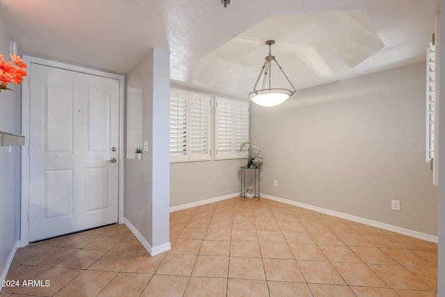 foyer entrance featuring light tile patterned floors and a textured ceiling