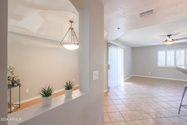 hallway featuring light tile patterned flooring and a textured ceiling