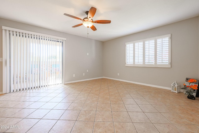 empty room with ceiling fan and light tile patterned floors