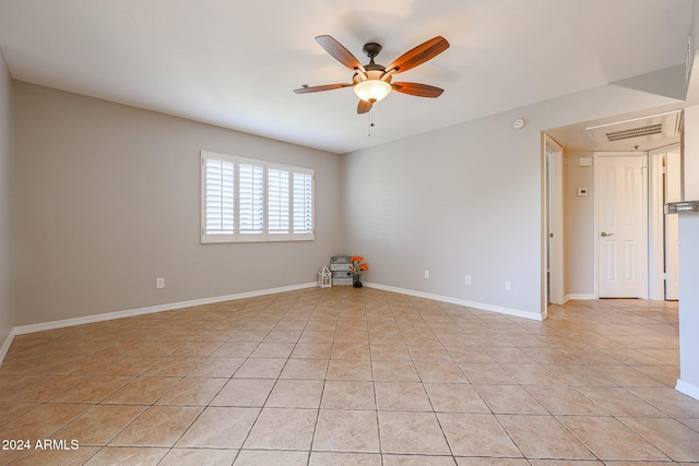 tiled spare room with ceiling fan