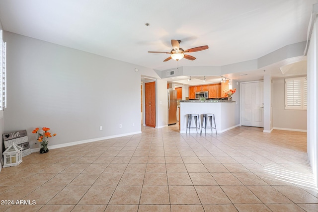 unfurnished living room featuring light tile patterned floors and ceiling fan