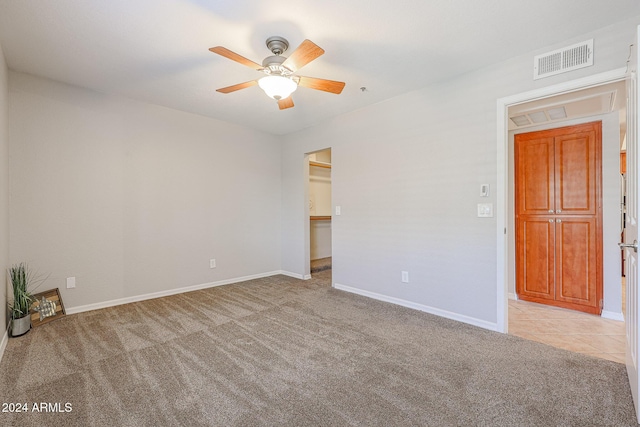 unfurnished room featuring ceiling fan and light colored carpet