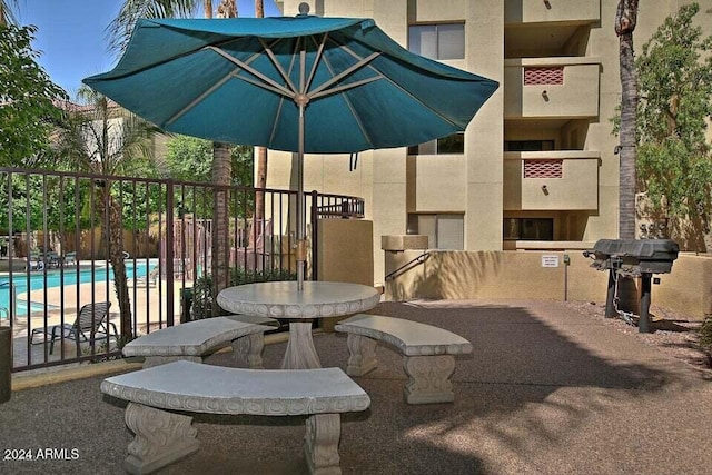 view of patio / terrace with a grill and a community pool