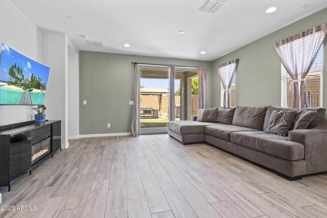 6919 S 13th Pl, Phoenix, AZ 85042 - living area with light wood-style flooring, a glass covered fireplace, and recessed lighting