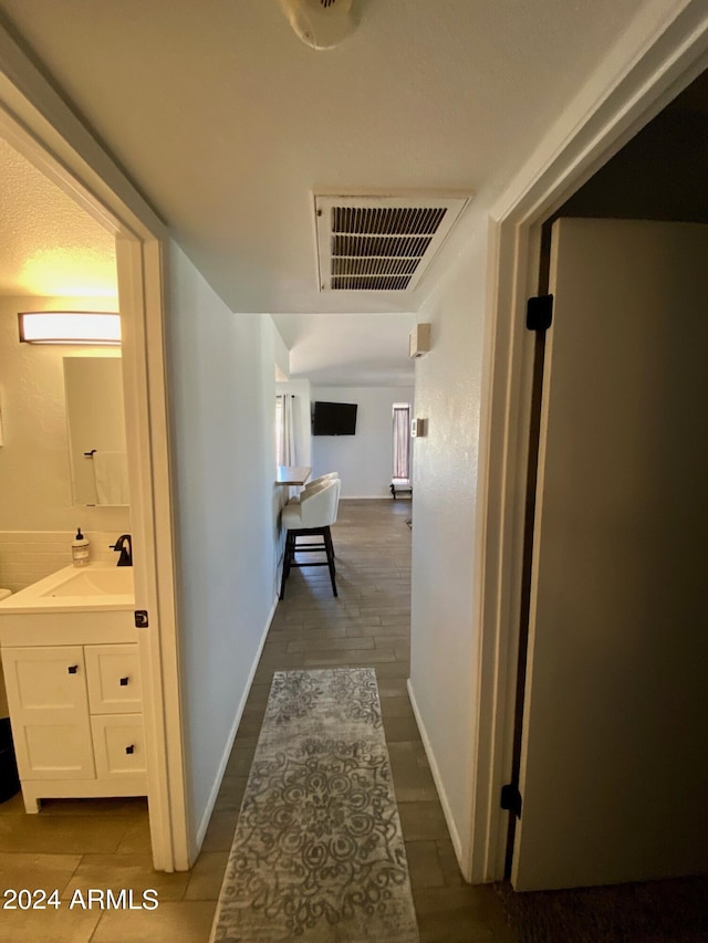 corridor with sink and hardwood / wood-style flooring