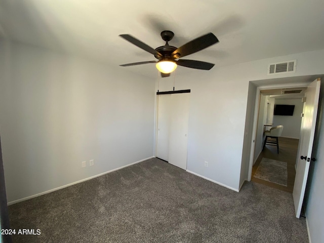 unfurnished bedroom featuring dark colored carpet and ceiling fan