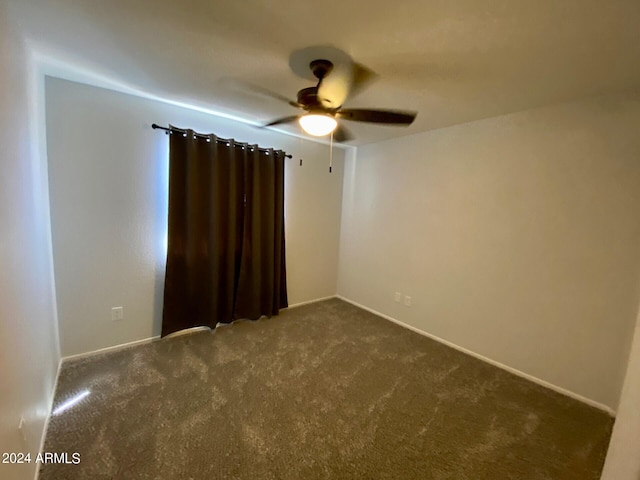 unfurnished room featuring dark carpet and ceiling fan