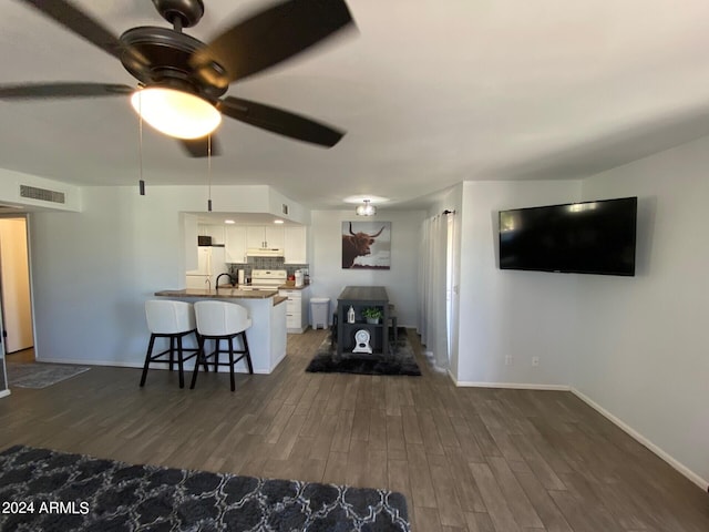 living room featuring dark wood-type flooring and ceiling fan