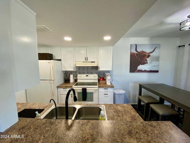 kitchen with white cabinets, tasteful backsplash, sink, and white appliances