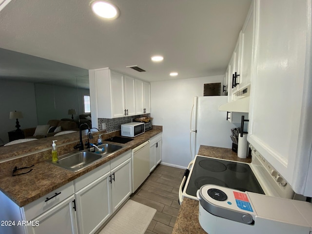 kitchen featuring wood-type flooring, range hood, sink, white cabinetry, and white appliances