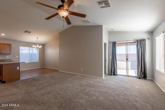 unfurnished living room featuring ceiling fan with notable chandelier, lofted ceiling, and light carpet