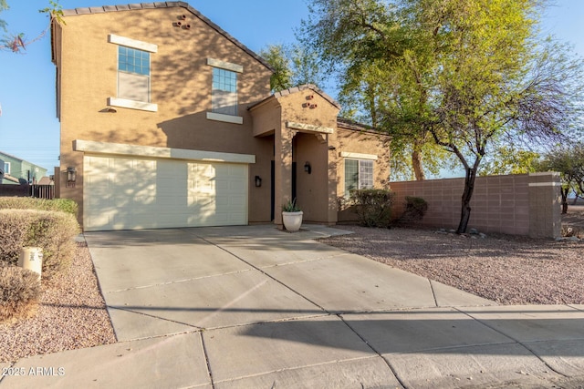 view of front facade with concrete driveway, fence, a garage, and stucco siding