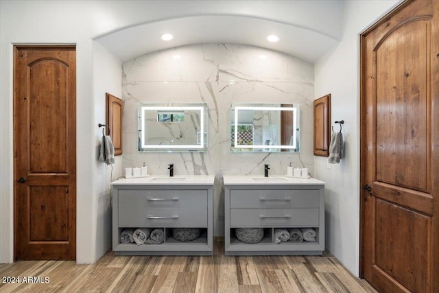 bathroom featuring hardwood / wood-style flooring, vanity, and backsplash