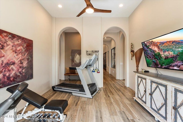 workout area with light hardwood / wood-style flooring and ceiling fan