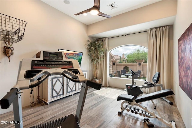 workout area with ceiling fan and light hardwood / wood-style floors