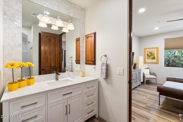 bathroom featuring vanity, a shower, and wood-type flooring