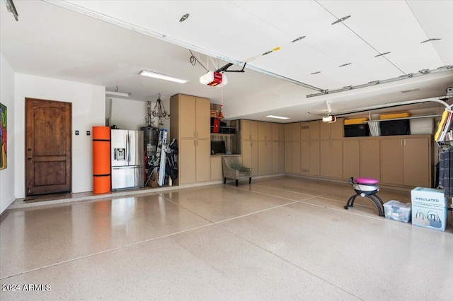 garage featuring stainless steel refrigerator with ice dispenser and a garage door opener