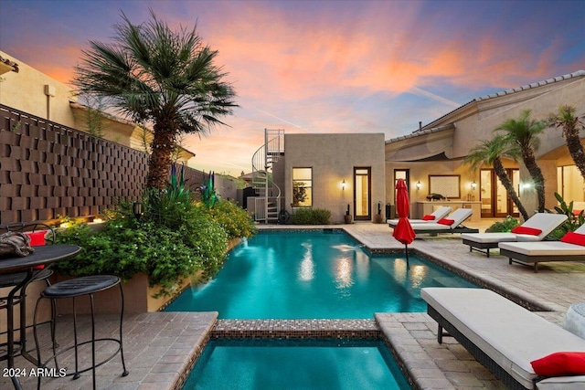 pool at dusk featuring a patio