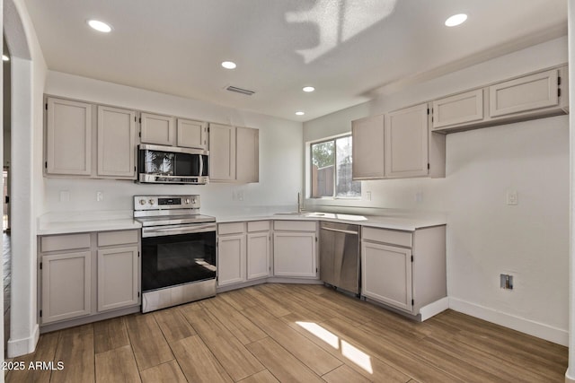 kitchen featuring light wood-style flooring, appliances with stainless steel finishes, and light countertops