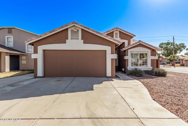 view of front of home with concrete driveway, a tile roof, and stucco siding