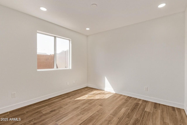 unfurnished room with recessed lighting, wood finished floors, and baseboards