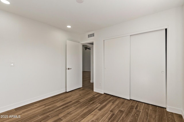 unfurnished bedroom featuring visible vents, baseboards, recessed lighting, wood finished floors, and a closet